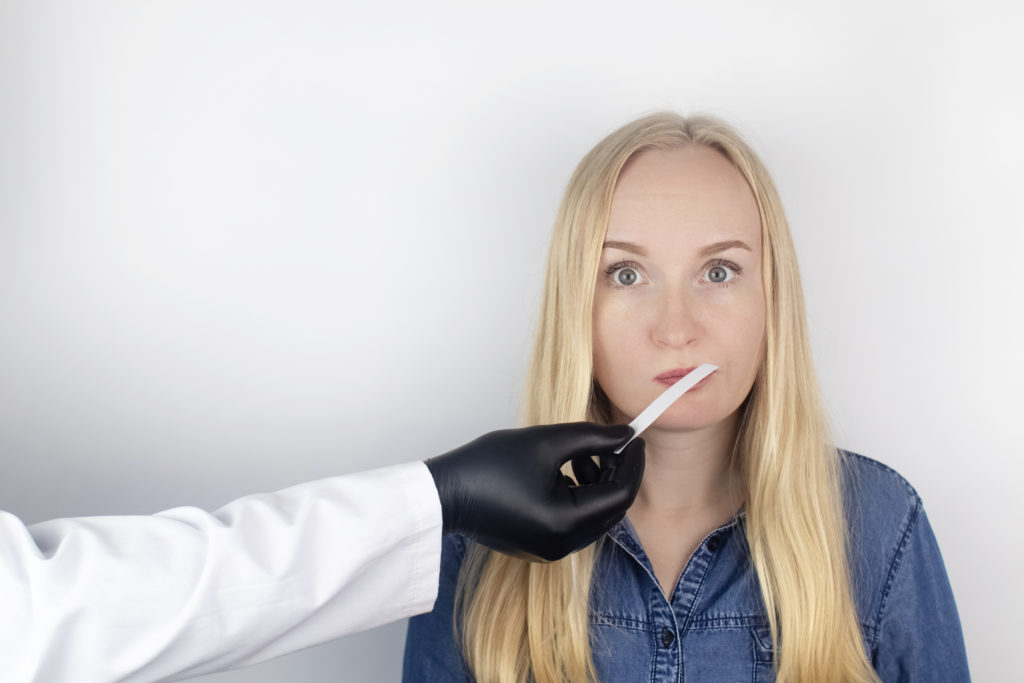 blonde lady looks confused as she cannot identify a smell on a smell strip