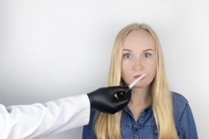 blonde lady looks confused as she cannot identify a smell on a smell strip
