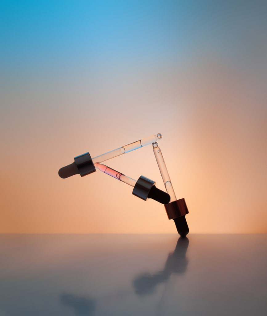 three pipette droppers balancing on each other in a triangle shape